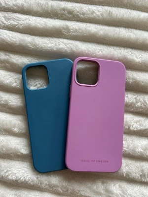 Mobilskal till iphone 12 - Säljer 2st mobilskal till iphone 12 i rosa och i blått, det rosa är ifrån Ideal of Sweden 💗 super bra skick men den blåa har en liten släppning vid ena kanten! Båda är i silecon 💕