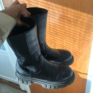Svarta boots från Buffalo  - Svarta boots med grov sula och högt skaft. De har en stilren design med dragöglor baktill för enkel påtagning. Bakom står det Buffalo. Köpte dem i zalando:)