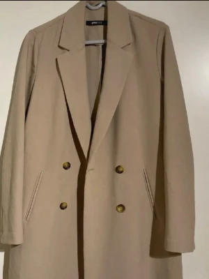 Beige  kappa  - Stilren beige kappa från Gina Tricot i storlek 38 men passar en 36 också. 