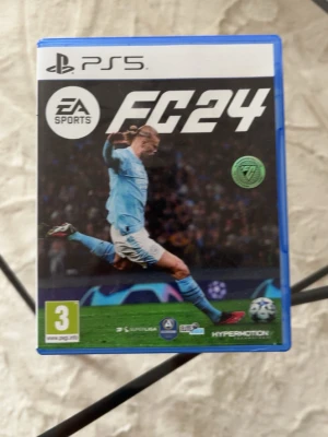 EA Sports FC24 till PS5 - Säljer spelet EA Sports FC24 till PlayStation 5. Omslaget är blått och spelet har en fotbollsspelare i ljusblå matchställ på framsidan. Perfekt för dig som gillar fotbollsspel och vill spela de senaste ligorna och lagen.
