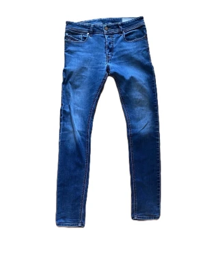 Blå slim fit jeans diesel - Snygga blå slim fit jeans med klassisk femficksdesign, jeansen är i storlek w29 L30. Dom har ett hål därfram men annars är dom i gott skick. Priset är ej hugget i sten