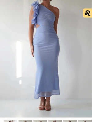 Ljusblå one shoulder klänning Oh Hello clothing - Säljer en ljusblå långklänning från Oh hello clothinf i storlek XS. Klänningen har one shoulder-design med stora volangdetaljer på axeln och är figurnära. Perfekt för dig som vill sticka ut med en elegant och unik look. Använd endast 1 gång