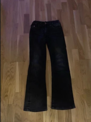 Svarta bootcut jeans - Säljer ett par svarta bootcut jeans med snygga broderade rosetter på bakfickorna i strl 158. Passar till precis allt, mycket bra skick! 💞