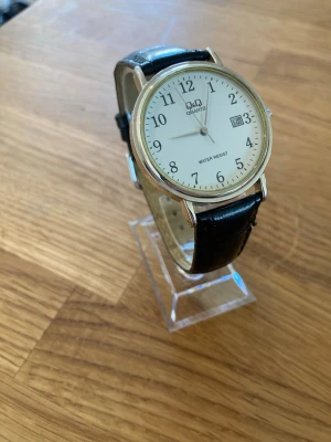 Citizen Q&Q Date Dress 36mm Herrklocka - Säljer en snygg stilren dressklocka till herr från japanska Q&Q (Citizen) i nyskick enligt bilder. Fungerar bra, originalarmband i äkta läder, datumvisare, vattentät, japanskt urverk, mineralglas osv. Behöver bara nytt batteri.  Nypris: < 900 SEK Mitt pris: 389 SEK  Skickas alltid snabbt och spårbart. Skriv vid frågor och se gärna mina andra annonser!   GRATIS: För betalande kunder erbjuder jag personlig experthjälp för dig att göra nya fynd (nytt & begagnat). Fråga för mer info!