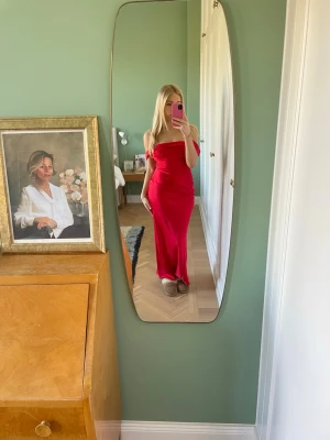 Röd långklänning - Säljer en röd långklänning med figurnära passform. Klänningen är supersnygg och stilren och passar perfekt som balklänning!