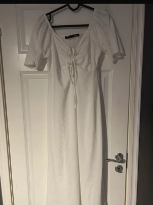 Lång vit sommarklänning med puffärmar & snörning - Drömmig lång vit klänning med korta puffärmar och feminin v-ringning. Snörning framtill vid bysten som ger en fin detalj Perfekt till sommarfester, semester, midsommar eller student 🤍☀️(ifrån lager 157) 