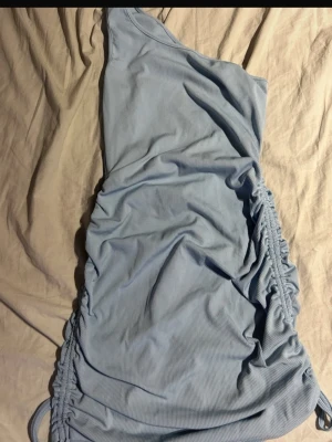 Ljusblå one shoulder-klänning - Trendigt ribbad kortklänning i ljusblå nyans med one shoulder-design. Snörning i sidorna som ger en smickrande passform och extra detalj Perfekt till fest, middag eller sommarens alla planer 💙✨(ifrån shein) 