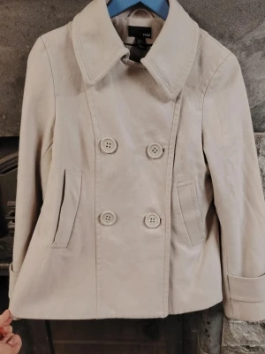 Beige dubbelknäppt jacka från H&M🩷  - Stilren beige jacka från H&M med dubbelknäppning och stora knappar framtill. Jackan har bred krage, två snedställda fickor och är tillverkad i ett mjukt tyg som känns som bomull. Perfekt för dig som gillar klassisk men avslappnad stil.🍀 XS-M. 