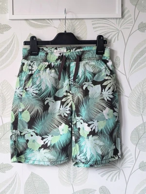Shorts Lindex Storlek 152 - - Tunna luftiga shorts perfekt för varmare dagar.  - I jättefint skick och sparsamt använd.  Jjag hittar inget att anmärka på mer än att resåren ser lite ojämn ut och lite ludd i fickorna.  - Det är svårt att få exakta färgen den är grön på bild kan den se mer turkos ut .  - Jag kan ha missat någon miniskavank men jag har försökt att granska plagget så gott det gårr
