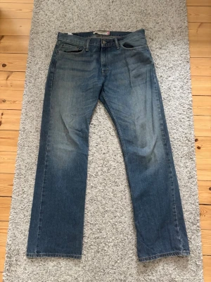 Blå Levi's 514 - Säljer mina Levi's 514 i storlek 34/32. Jeansen har en snygg vintage tvätt och sitter luftigt. Små slitningar vid benöppningen och en liten svart missfärgning på vänster ben (kolla bild 6 & 7). Tveka inte att höra av er vid frågor!