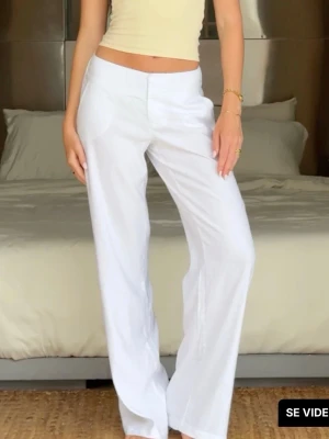 Vita linnebyxor med raka ben - Säljer ett par vita linnebyxor med raka ben och hög midja. Byxorna har enkel knappstängning och fickor framtill. Perfekta för en avslappnad och stilren look. Materialet är lätt och luftigt linne, vilket gör dem sköna att bära under varma dagar.