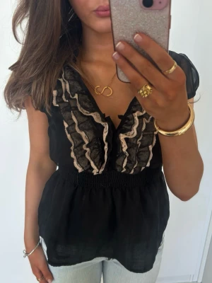 Vringad volangtopp med spets - Såå fin svart vringad volangtopp med rosa och svart spets. Jag är 168 och det är mina bilder, köp via köp nu direkt eller Swish, kvar tills markerad som såld 💖 storlek 40, passar M. 