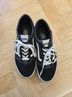 Svarta Vans Old Skool sneakers - Säljer ett par klassiska svarta Vans sneakers med vit sula och snörning.