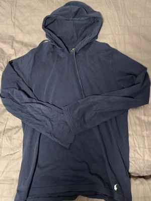 Ralph Lauren Hoodie - Tja säljer nu en Ralph Lauren Hoodie i storlek M och färgen Marinblå. Se defekt sista bilden litet slitage inga andra defekter. Hör av dig vid frågor eller funderingar