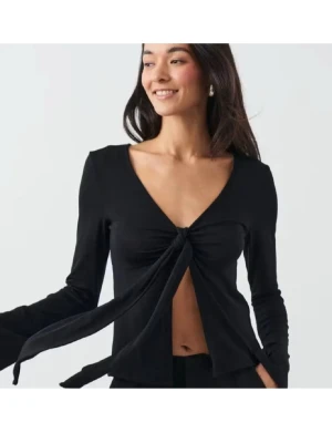 Svart långärmad topp  - Trendig svart långärmad topp med v-ringning och knyt framtill. Sitter snyggt och har en figurnära passform som framhäver siluetten. Perfekt att styla med jeans eller kjol för en cool look. Den är i storlek XS och från Gina, knappt använd❣️
