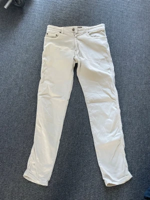 Vita/beige jeans från Cavalierre - Säljer ett par stilrena vita/beige jeans från Cavalierre med klassisk femficksmodell och dragkedjegylf. Jeansen har raka ben och är tillverkade i ett mjukt bomullstyg med diskreta detaljer. Perfekta för dig som vill ha en clean och fräsch look. 
