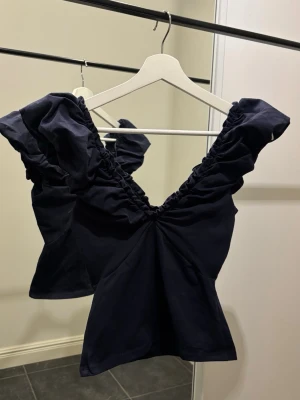 Navy topp / blus - Topp med öppen rygg & urringning. Mörkblå. Stl xs. Aldrig använd. Köpt i Italien i en butik. Kan skickas / hämtas