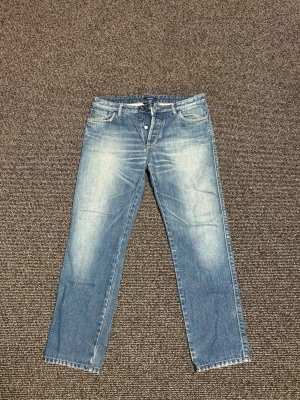 KYLE jeans gant  - Säljer ett par klassiska blå jeans från Gant med raka ben och snyggt slitna detaljer framtill och baktill. Jeansen är kortade annars är storleken W32/L32 men den är kortade och längden ser man på en av bilderna i cm