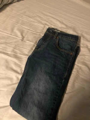 Levi's blå slim jeans 12A - Snygga blå jeans från Levi's i modellen 512 Slim Taper. Klassisk femficksdesign, gul kontrastsöm och lätt tvättad look. Perfekta för dig som gillar en smalare passform och tidlös denimstil.