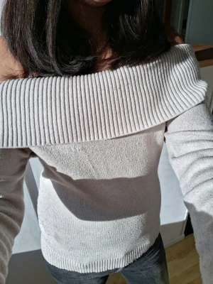 Beige off shoulder tröja - Hejj jag säljer en beige off shoulder-tröja med bred ribbad kant runt axlarna. Tröjan har lång ärm och är tight. Materialet känns mjukt och bekvämt mot huden. Den har en liten skada på framsidan som jag har sytt ihop men det syns knappt. Den är 158/164 men passar som en xs eller s