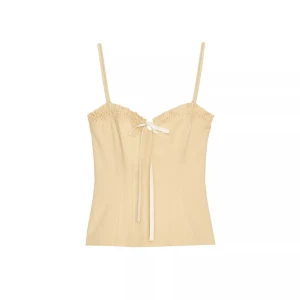 Gul  korsettopp med rosett - Trendig gul  korsettopp med smala axelband och söt rosettdetalj framtill. Aldrig använd 