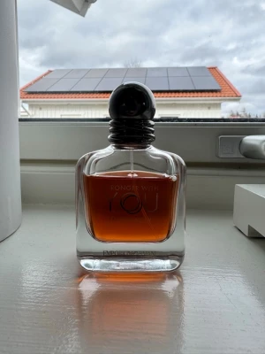 Emporio Armani Stronger With You intensely - Emporio Armani Stronger With You är en elegant parfym i en genomskinlig glasflaska med rundade kanter och svart rund kork. Doftvätskan är bärnstensfärgad och flaskan har en stilren, modern design med märkets logga ingraverad. 50ml som nästan är full
