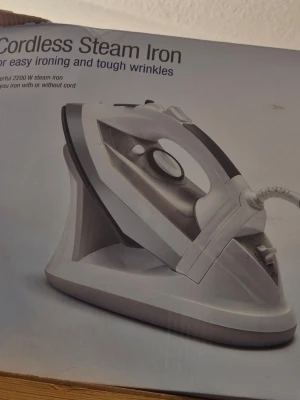 Sladdlös ångstrykjärn - Säljer ett sladdlöst ångstrykjärn i vitt och grått med modern design. Strykjärnet har en kraftfull effekt på 2200 W och kan användas både med och utan sladd. Perfekt för att få bort tuffa veck och göra kläderna snygga snabbt.