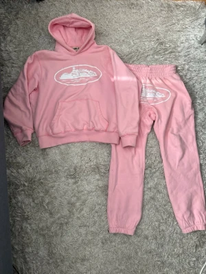 Rosa corteiz set/tracksuit - Säljer rosa corteiz set/tracksuit med vitt tryck framtill. Materialet är mjukt och bekvämt, perfekt för chill dagar. 