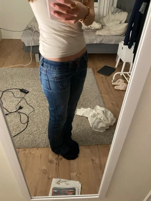 Blå bootcut jeans från ONLY - Säljer ett par jättesnygga blå bootcut jeans från ONLY med klassisk femficksmodell och snygga slitningar. Jeansen har låg midja, dragkedja och knapp framtill samt kontrastsömmar. Storleken står som waist: 25 och length:32men passar mig som brukar ha xs/s i jeans 💗💗