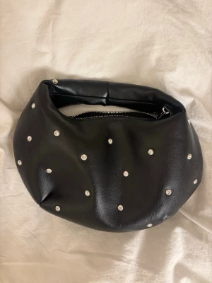Svart handväska med pärlor. - En svart väska från gina, aldrig använt. 