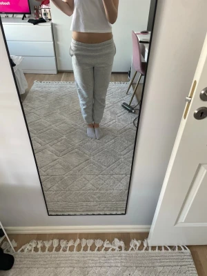 Ljusgråa mjukisbyxor med resårmidja - Säljer ett par ljusgrå mjukisbyxor med resår i midjan och ankellånga ben. Byxorna har en avslappnad passform och är tillverkade i mjukt sweatshirtmaterial, perfekta för chill dagar hemma. Klassisk modell utan synliga loggor eller detaljer.