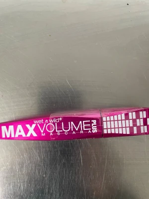 Wet n Wild Max Volume Plus Mascara - Max Volume Plus Mascara från Wet n Wild i en snygg metallicrosa tub med vit text och grafiskt mönster. Ger fransarna extra volym och har en modern, stilren design som sticker ut i sminkväskan.                    Oöppnad inplastad 