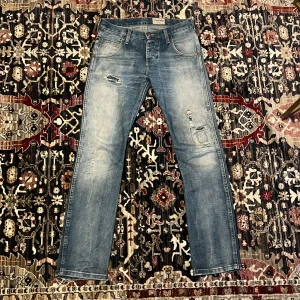 Blå slitna jeans från Wrangler - Säljer ett par blå jeans från Wranglermed slitningar och patchdetaljer på benen. Storlek 29-30/32 sitter rakt. Går gärna ner i pris vid snabb affär