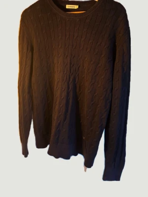 J.Lindeberg kabelstickad tröja  - Stickad tröja från J.Lindeberg i mörkblå/marinblå kabelstickning. Klassisk och tidlös modell som passar lika bra till vardag som till mer uppklädda tillfällen. Märkt storlek L men upplevs som något mindre i passformen, snarare som M. Tröjan är i gott skick och väl omhändertagen. Säljes då jag själv har vuxit ur den och den inte längre kommer till användning.