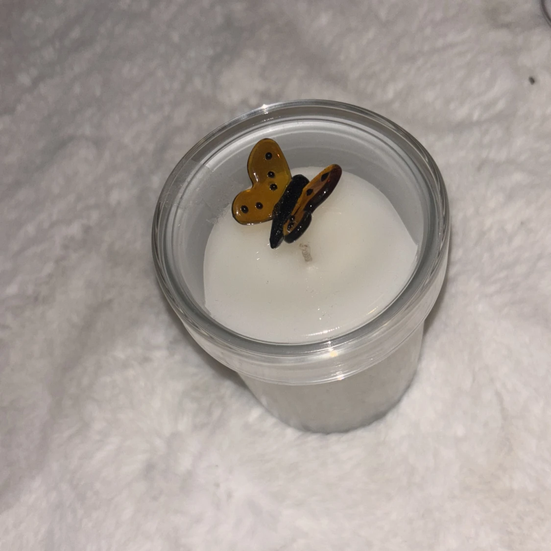 Vit doftljus i glas med fjäril