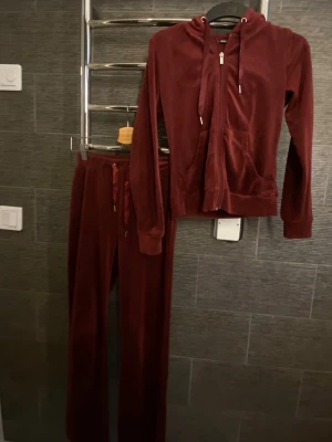 Vinrött mjukissett från Gina Tricot  - Mysigt loungewear-set i vinröd velour med zip-hoodie och matchande byxor med dragsko i midjan. Hoodien har fickor och långa ärmar, byxorna är raka och mjuka. Storlek är xxs men passar mig perfekt som vanligtvis har xs/s och är 170 lång. 