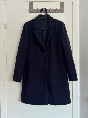 Mörkblå ullkappa från Zara - Stilren mörkblå ullkappa från Zara med klassisk krage och två knappar framtill
