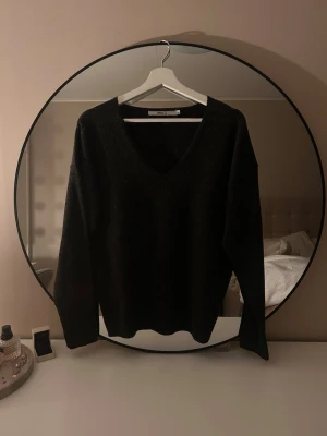 Svart stickad V-ringad tröja - Säljer en svart stickad tröja från only med djup V-ringning och långa ärmar💕 Tröjan har en avslappnad passform och är perfekt för lager-på-lager-stil. Enkel och stilren design som passar till det mesta🥰