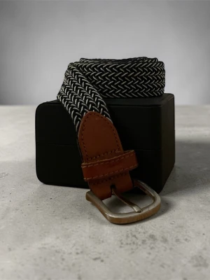 Svartvitt flätat bälte - Snyggt svartvitt flätat bälte med bruna läderdetaljer och silverfärgat spänne. Perfekt accessoar för att lyfta din outfit med en cool kontrast och klassisk look. Passar till jeans Med vänlig hälsning, Valter 😉