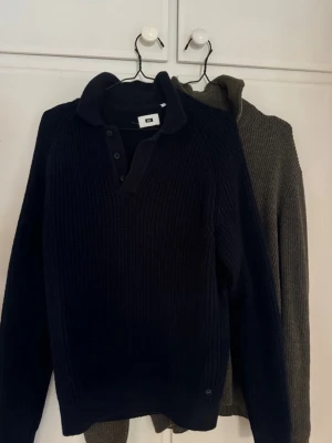 Stickade tröjor x2 - Paket av 2 stycken väldigt fina stickade tröjor, en med knapp och en halfzip. Olivgröna halfzipen använd några gånger, blåa tröjan använd ca 1-2 gånger. Båda är storlek M