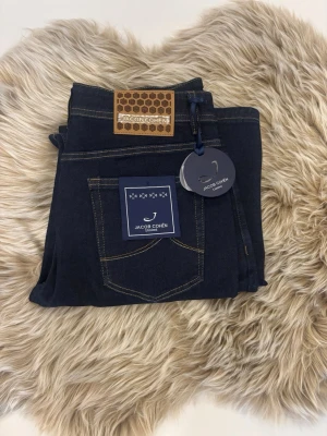Mörkblå jeans från Jacob Cohen - Säljer ett par  jeans från Jacob Cohen med en sjukt snygg mörkblå tvätt, i ny skick då dom endast är testade alla tags och liknande finns kvar! Storlek 32 är dom i!