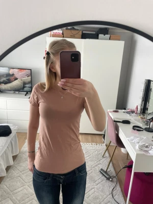 Beige t-shirt från Our Best Basics - En enkel och snygg beige t-shirt från Our Best Basics i ekologisk bomull. T-shirten har korta ärmar och en rund halsringning. Perfekt för dig som gillar en clean och stilren look.