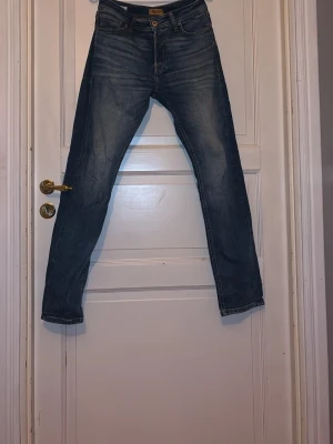 Blå tapered jeans Tapered Mike -  Tjena! Säljer nu mina mörkblå jeans ifrån Jack ändå Jones. Jeansen har orangea sömmar och en  lätt tvättade lock. Perfekta för en avslappnad och trendig stil.