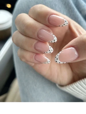 Handgjorda lösnaglar 💞 - Snygga press-on naglar i mandelform med transparent bas och vit fransk tipp dekorerad med svarta prickar.