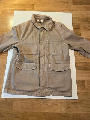 Beige overshirt jacka från H&M. Pris kan diskuteras - Helt oanvänd snygg beige overshirt jacka från H&M med klassisk krage och fyra stora fickor framtill. Tillverkad i bomull med raka linjer och enkel design som passar till många olika stilar. Perfekt lager-på-lager-plagg för vår och höst.