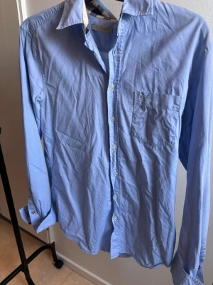 Ljusblå skjorta från Burberry - Hej, Säljer denna riktigt snygga burberry skjortan! Säljes i fint skick, Storlek M kan passa om du har L också. Ej struken!