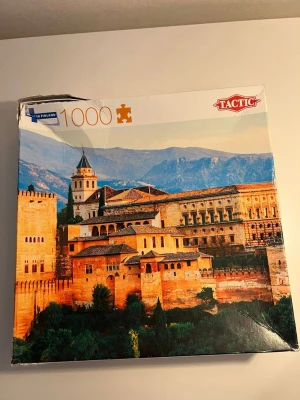 Tactic pussel 1000 bitar Alhambra - Säljer ett pussel från Tactic med 1000 bitar som föreställer Alhambra i Spanien. Motivet har varma toner av orange, gult och grönt med berg i bakgrunden. Pusslet kommer i originalkartong och är tillverkat av kartong.