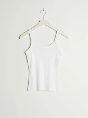 Vitt ribbat linne  - Säljer ett enkel och stilrent vitt ribbat linne med smala axelband. Toppen har en kroppsnära passform och är perfekt att matcha med jeans eller kjol. Aldrig använt pga av att jag beställde fel storlek. 