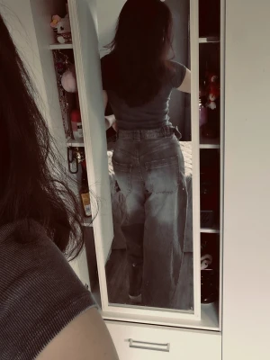 Baggy grå jeans med hög midja - Säljer ett par baggy grå jeans med hög midja och raka, vida ben. Jeansen har slitna detaljer och klassiska fem fickor. Perfekta för en avslappnad och trendig look. Materialet är denim i bomull. Inte använda. 