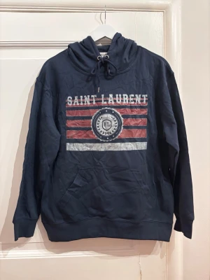 Saint Laurent Hoodie - Blå Saint Laurent Hoodie. Storlek: M, sitter mer som S. Skick: 9/10. Fraktar inom 24 timmar. Fråga på!